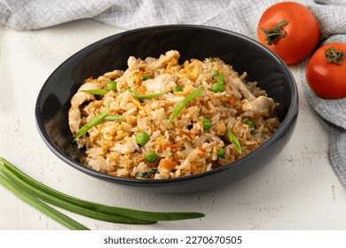 Fried rice with chicken and vegetables, rice with meat in a black mask on a beautiful table restaurant background