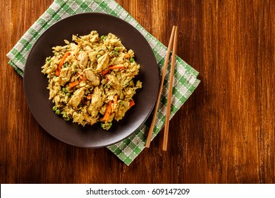 Fried Rice Nasi Goreng With Chicken And Vegetables On A Plate. Indonesian Cuisine. Top View