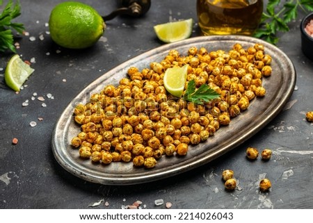 Fried roasted spicy chickpeas or Indian chana or chole with lime. Tasty vegetarian and vegan chickpea snack. Food recipe background. Close up.