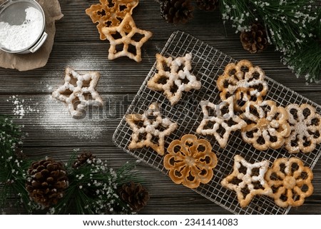 Fried rosette snowflake and star cookies with confectioners sugar dusting holiday cookie