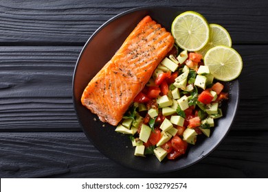 Fried Salmon Steak With Avocado Tomato Salsa Closeup On A Plate. Horizontal Top View From Above
