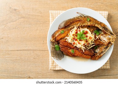 Fried Sea Bass Fish with Fish Sauce and Spicy Salad on plate