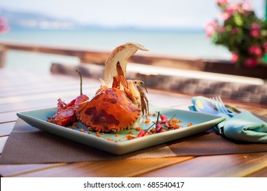 Fried sea crab served with lettuce, bread and sauce in chili pepper on beach