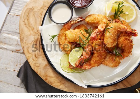Fried Shrimp with Sauce. Shrimp tempura and salad of fresh vegetables close-up on a plate on a table.