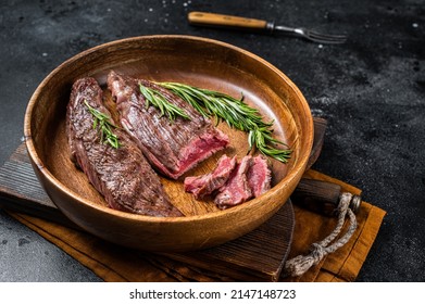 Fried Sirloin Flap Or Flank Beef Steak With Herbs In A Wooden Plate. Black Background. Top View.