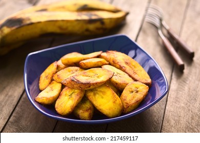 Fried Slices Of The Ripe Plantain In Blue Bowl, Which Are Eaten As Snack Or Used To Accompany Dishes In Some South American Countries (Selective Focus, Focus On The Front Of The Upper Plantain Slice)