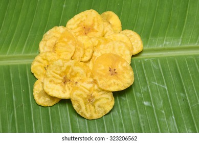 Fried snack Banana chips from Kerala cuisine fried in coconut oil.Dried banana slices isolated on a banana leaf background, Kids favourite .India. Vishu and Onam side dish