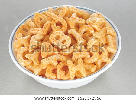 Fried and Spicy ABCD, Alphabet Snacks or Fryums (Snacks Pellets) served in a white bowl. selective focus - Image