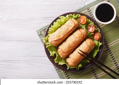 fried spring rolls on a plate with salad, horizontal view from above