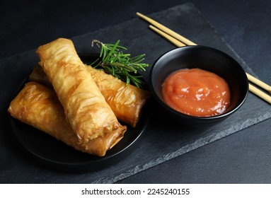 Fried spring rolls with sweet chili sauce on dark background. Asian cuisine. - Shutterstock ID 2245240155
