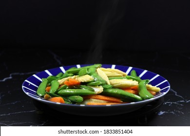 Fried And Stirred Sliced Baby Corn, Carrot And String Bean On The Plate. Famous Traditional Vegetarian Menu In Chinese Restaurant. High Fiber And Low Fat Food. 