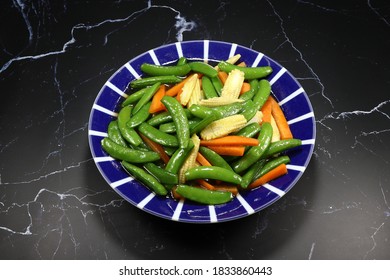 Fried And Stirred Sliced Baby Corn, Carrot And String Bean On The Plate. Famous Traditional Vegetarian Menu In Chinese Restaurant. High Fiber And Low Fat Food. 