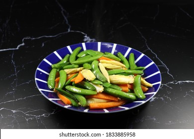 Fried And Stirred Sliced Baby Corn, Carrot And String Bean On The Plate. Famous Traditional Vegetarian Menu In Chinese Restaurant. High Fiber And Low Fat Food. 