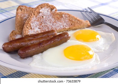 Fried Sunny Side Up Eggs With Sausage Links And Buttered Wheat Toast.