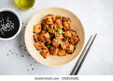 Fried teriyaki tofu with scallions and sesame seeds. Healthy vegan meatless meal rich in protein and calcium. Asian tofu meal - Shutterstock ID 1928144282