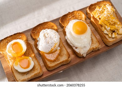fried Toast bread with four different types of cooked chicken eggs, scrambled eggs, fried eggs, poached egg and creamed egg. Breakfast of chicken eggs.