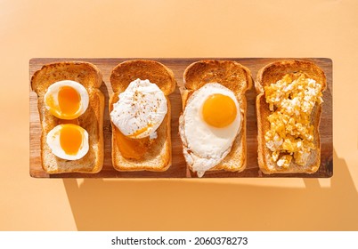 fried Toast bread with four different types of cooked chicken eggs, scrambled eggs, fried eggs, poached egg and creamed egg. Breakfast of chicken eggs.