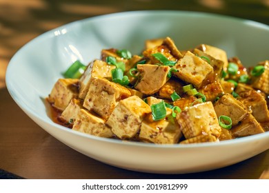 Fried Tofu In Sweet And Sour Sauce With Sichuan Pepper And Vegetables In A White Plate. Chinese Cuisine