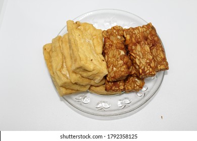 Fried Tofu And Fried Tempeh On A Small Glass Plate.