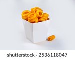 Fried and twisted curly fries in a carton, isolated on a white background. Curly fries