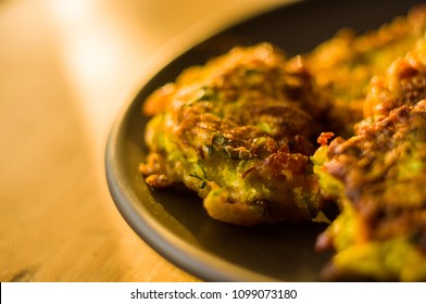 Fried vegetable fritters with zucchini, carrots, herbs, eggs, and cheese. - Shutterstock ID 1099073180