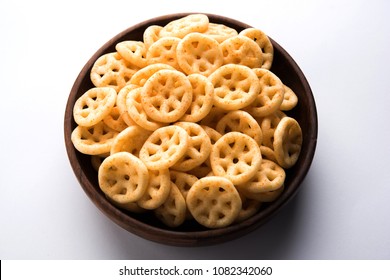 Fried wheel Snacks or Fryums served in a bowl or over moody background. selective focus
