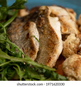 Fried white fish with greens. Close up shot. Food concept. Square format or 1x1 for posting on social media. Soft focus.