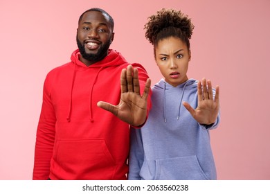 Friend asking stop worrying health raise palm forbidden enough dangerous gesture. Two african american man woman show hand prohibition taboo gesture persuading quit smoking, pink background