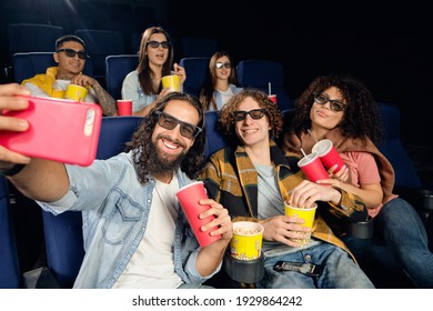 Friend in the cinema. Emotions of people watching amovie in a movie theater. Big group of young best friends, watching funny film at cinema, spending free time together, eating tasty popcorn.