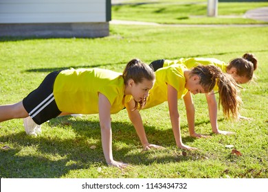 Friend girls teens push up push-ups workout ABS in a park turf grass - Powered by Shutterstock