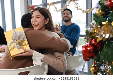 Friend giving a Christmas gift during a celebratory meal together - Powered by Shutterstock