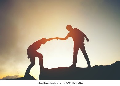 Friend Hiking Help Each Other Silhouette In Mountains