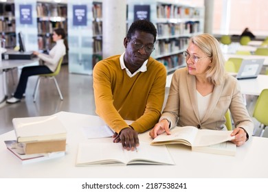 Friendly Adult Students Preparing In Library. High Quality Photo