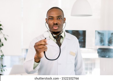 friendly african american doctor in modern office. Portrait of an handsome African man doctor, holding stethoscope