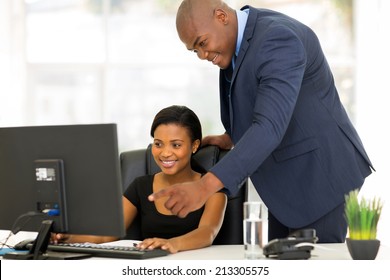 Friendly African Boss Guiding His New Employee With Her Work