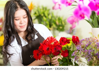 Friendly Asian Florist Or Saleswoman In A Flower Shop