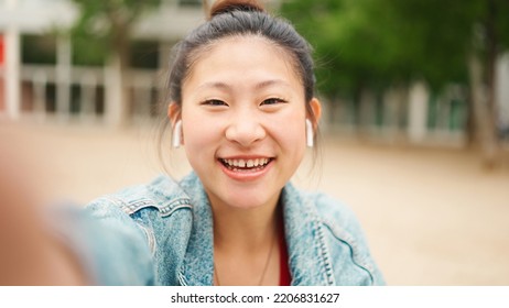 Friendly Asian Girl Making Content For Her Social Media Blog Enjoying Good Day On The Street. Attractive Japanese Woman Looking Happy Outdoors