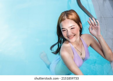 A Friendly Asian Lady Says Hi. Congenial Teen In A Cute Lavender Bikini Swimming In The Pool.