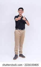 A friendly asian man points to the camera while smiling. Endorsing someone, making the thumbs up sign. Isolated on a white background. - Shutterstock ID 2226150405