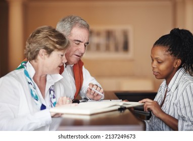 Friendly Assistance At The Reception Desk. A Senior Couple Filling Out Forms At The Hotel Reception Desk.