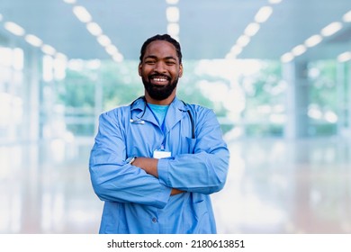 Friendly Black Male Doctor Portrait In The Hospital Clinic. Confident Man Professional Healthcare Worker Looking At Camera. Copy Space