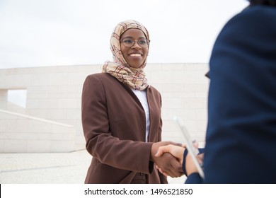 Friendly Business Lady Meeting And Thanking Coworker Outside. Muslim Business Women In Hijabs Standing Outdoors And Shaking Hands With Each Other. Muslim Women In Business Concept