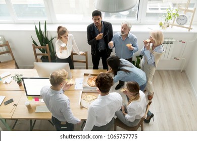 Friendly Business Team Of Diverse Young And Senior People Enjoy Eating Pizza Together, Employees Group Talking Sharing Meal In Office, Food Delivery Service At Lunch Time Concept, Top View Overhead