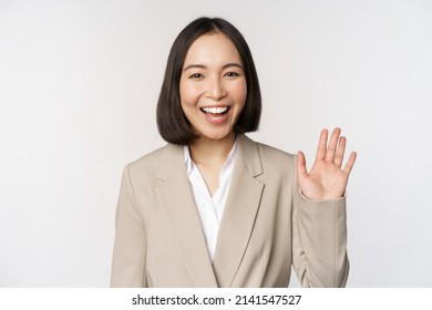 Friendly Business Woman, Asian Office Lady Waving Hand And Saying Hello, Hi Gesture, Standing Over White Background