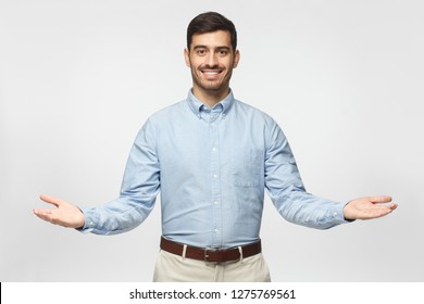Friendly businessman with welcoming gesture isolated on gray background