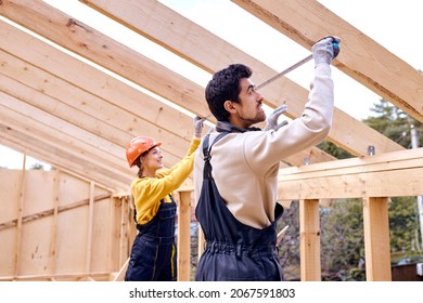 Friendly caucasian Contractors measuring the size and length of wooden beam, team of man and woman in work clothes uniform and hardhat using mesuring tape, having conversation.