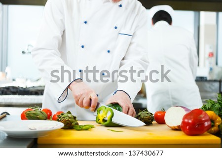 Friendly chef preparing vegetables in his kitchen