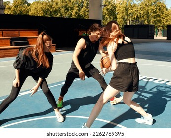 A friendly company of guys and girls are having fun on the basketball court, they are going to play basketball. - Powered by Shutterstock
