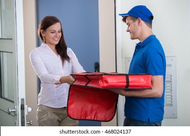 Friendly Delivery Man Handing Pizza To A Customer