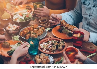 Friendly Dinner. Top View Of Group Of People Having Dinner Together While Sitting At The Rustic Wooden Table